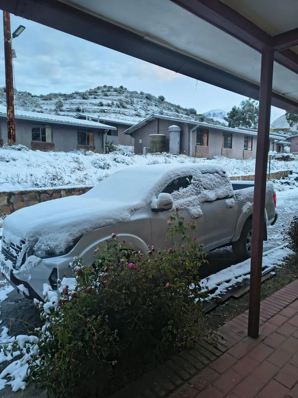 Camioneta cubierta de nieve en el patio del Hotel Las Vicuñas