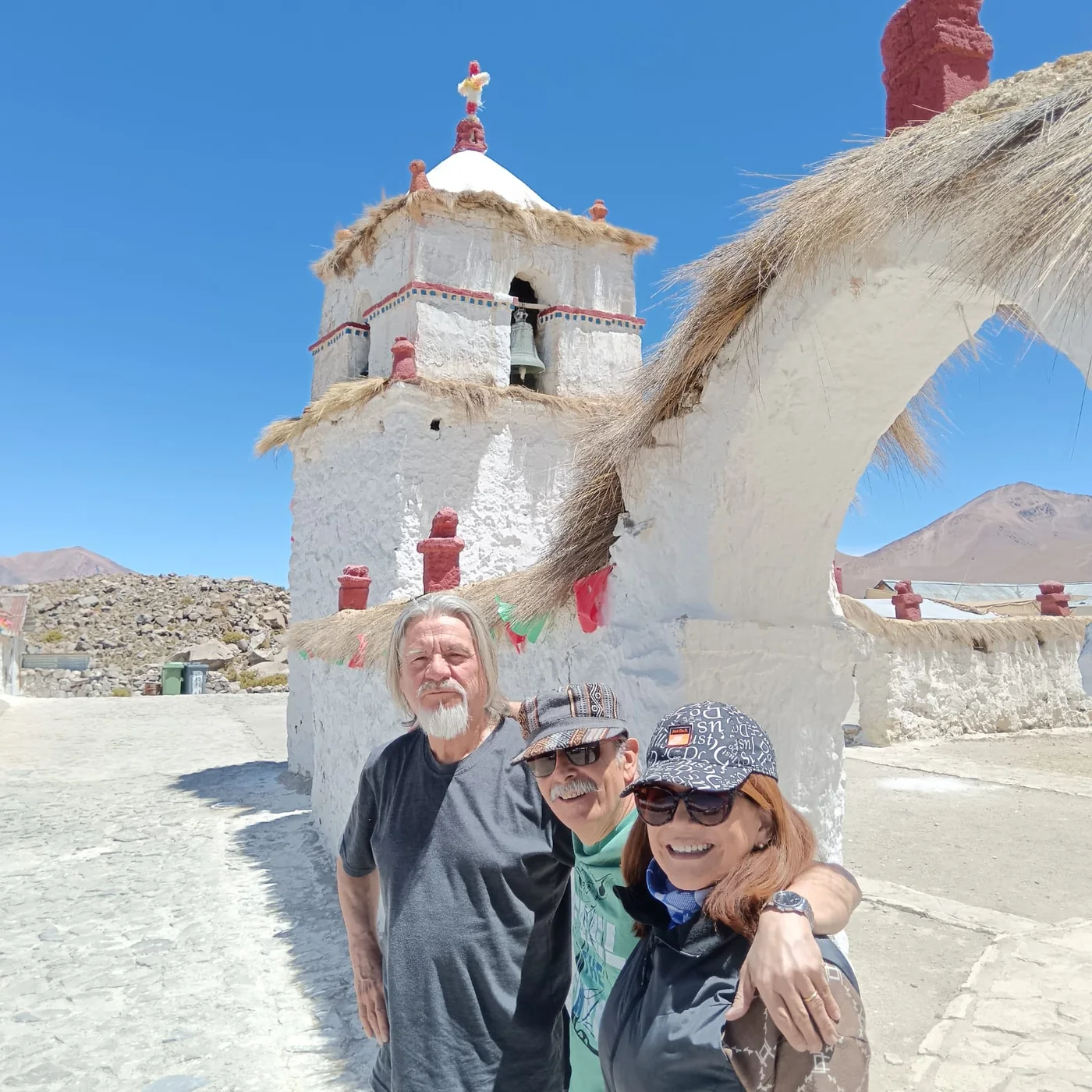Eduardo Oyarzún y pasajeros junto a la iglesia colonial de Parinacota, Monumento Nacional del siglo XVII