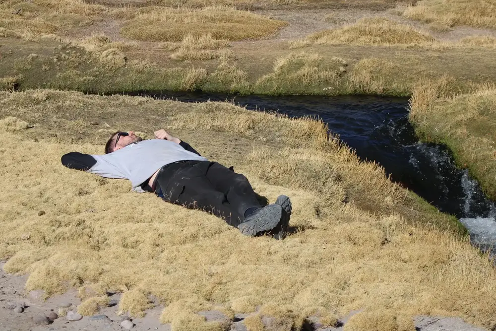 Pasajero relajado junto a un arroyo del altiplano