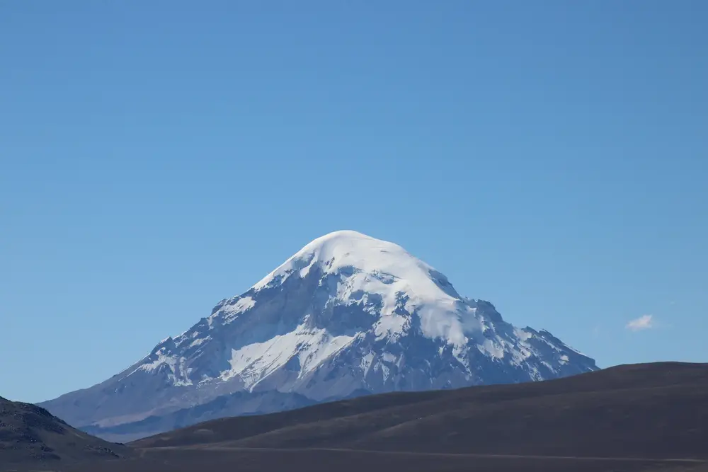 Pareja abrazada frente a una laguna turquesa del altiplano