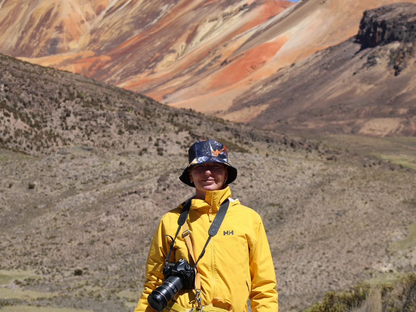 Pasajera de Villa Volcán Tours frente a los cerros de colores de Suriplaza, altiplano de Arica y Parinacota
